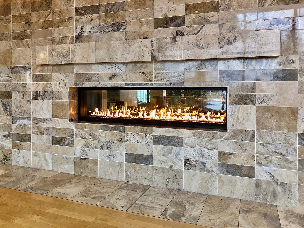 View of beautiful lit gas fireplace surrounded by modern tile, gas log fires Geelong, gas log fires Ballarat, gas fireplaces Geelong