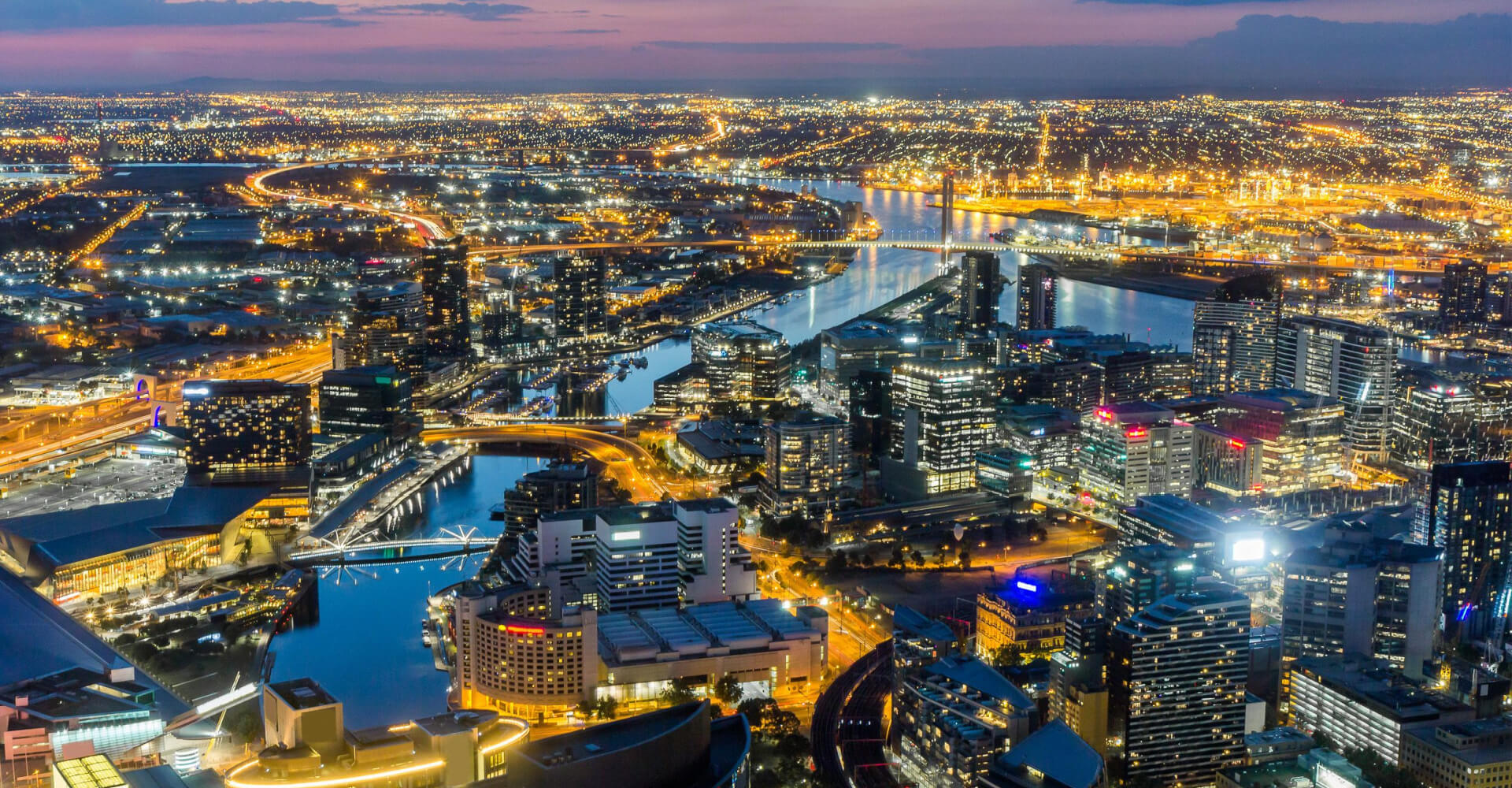 Melbourne City Aerial View Panorama Skyline Cityscape, Harbour, Seafarers Bridge, Bolte Bridge over Yarra River at Dusk Evening Sunset from Eureka Tower on South Bank, Victoria, Australia